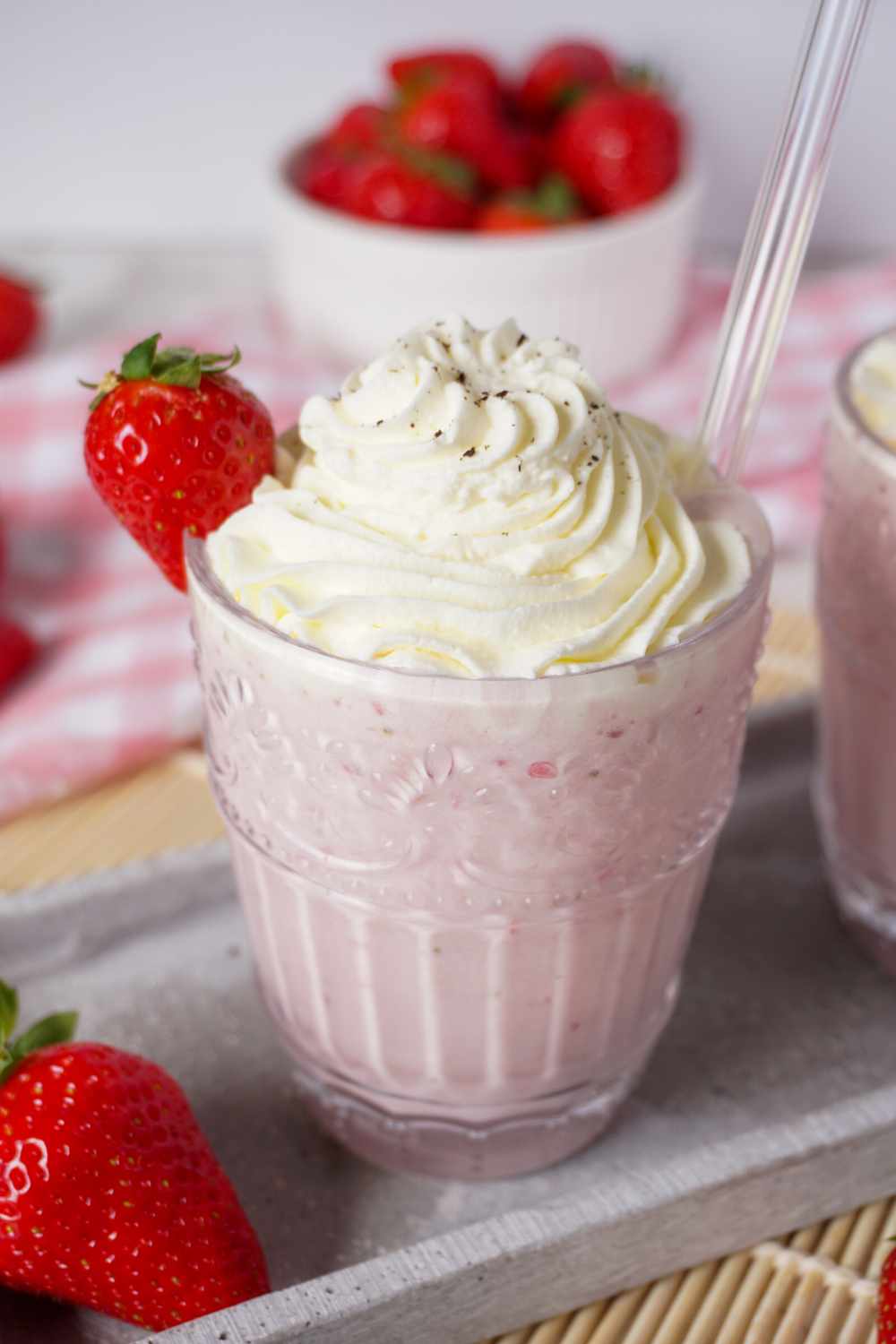 Erdbeermilchshake selber machen Erdbeermilchshake im Glas mit Sahne, Erdbeere und Strohhalm