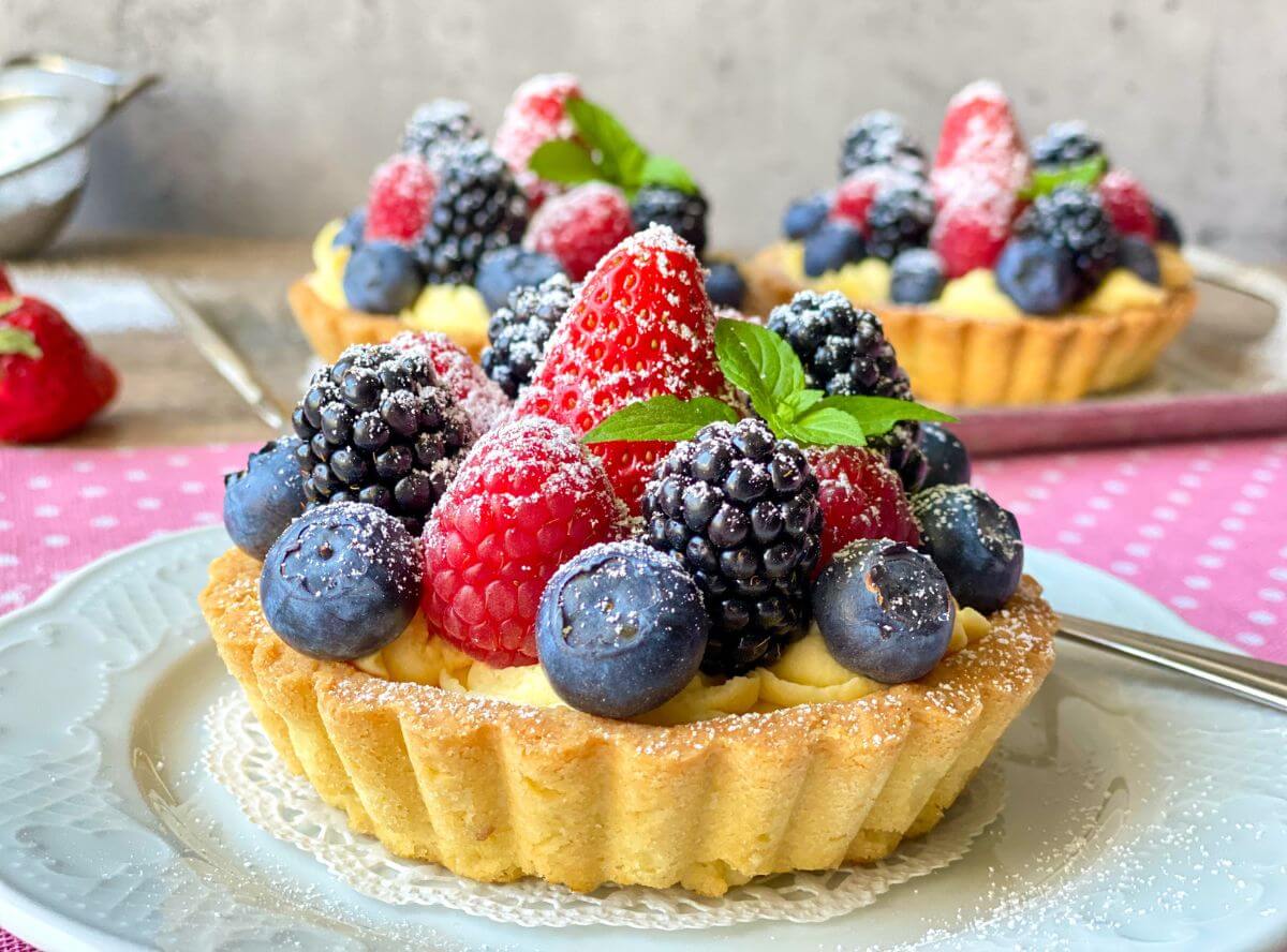 Torteletts aus Mürbeteig mit Pudding und Beeren