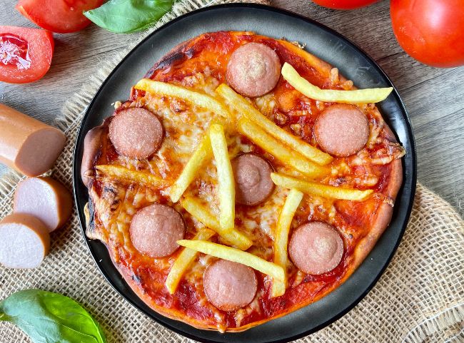 Pizza mit Wurst und Pommes